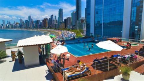 una piscina en la parte superior de un edificio con ciudad en Studio Beira Mar - Em frente RODA GIGANTE, en Balneário Camboriú