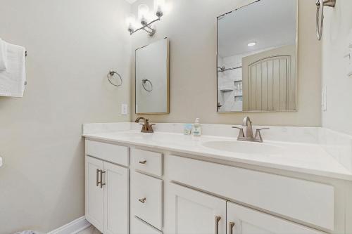Un baño blanco con dos lavabos y un espejo. en Beaufort Villas - A&B Duplex, en Beaufort