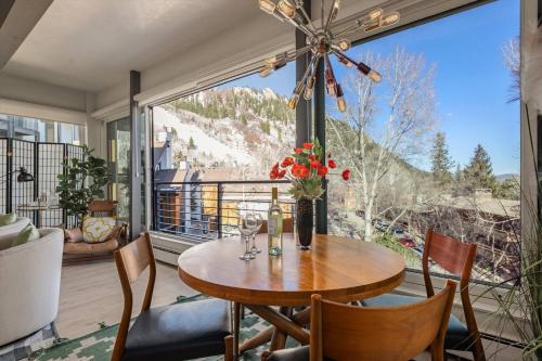 a dining room with a table and chairs and a large window at Durant 6D in Aspen