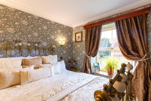 a bedroom with a large bed and a window at Brooklands 5 Star Guest House in Penrith