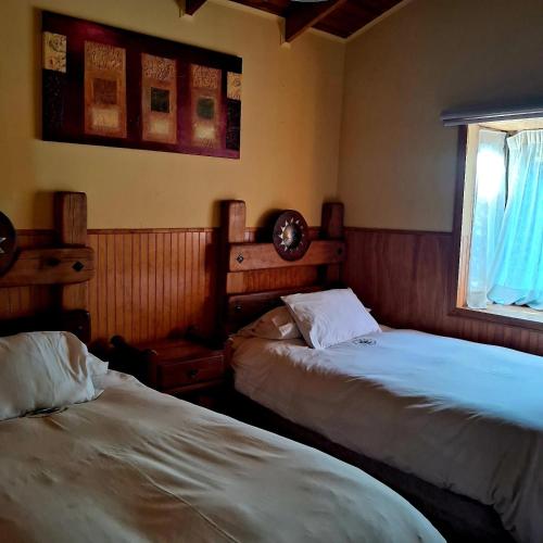 a bedroom with two beds and a window at Santuario del Río in San José de Maipo