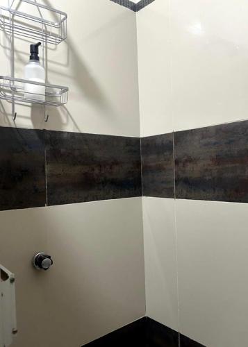 a bathroom with black and white tiles and a light at Alojamiento Jaén in Jaén