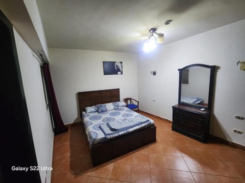 a bedroom with a bed and a dresser and a mirror at Porto Sokhna Pyramids Hotel Apartments in Ain Sokhna