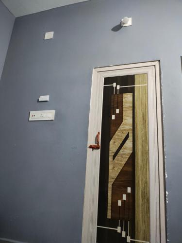 a hallway with a door with a painting of a staircase at Archana Guest House in Jagatpur