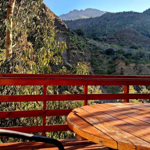a wooden bench sitting on top of a mountain at Santuario del Río in San José de Maipo