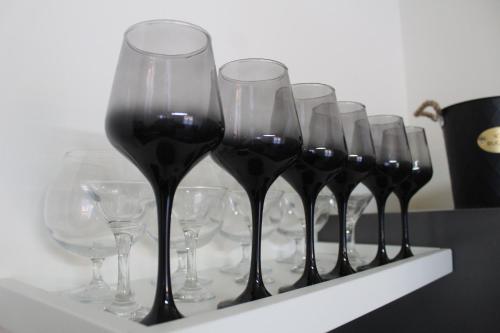 a row of wine glasses sitting on a shelf at TopView Apartment In front of Saranda Port in Sarandë