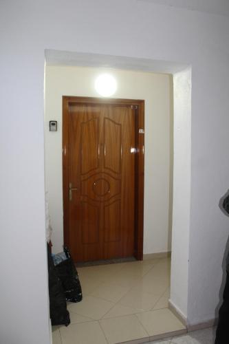 a hallway with a wooden door with a light on it at TopView Apartment In front of Saranda Port in Sarandë