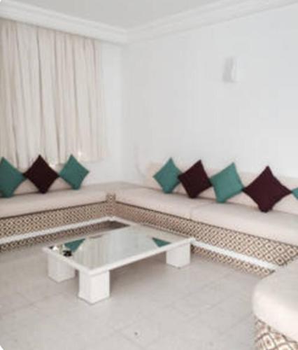 a living room with a couch and a coffee table at Aux jardins de Hammamet in Hammamet