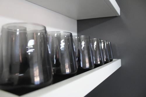 a row of wine glasses sitting on a shelf at TopView Apartment In front of Saranda Port in Sarandë