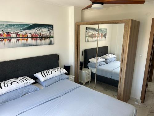 a bedroom with two beds and a mirror at Apartamento costa del sol in Torremolinos