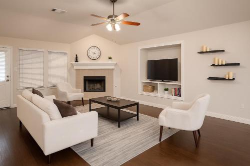 a living room with a white couch and a fireplace at Spacious 3BR Home w Game Room, Gym & Study in McKinney
