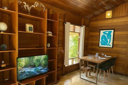 a living room with a tv and a table and a television screen at Casa de Campo no Circuito das Águas in Socorro