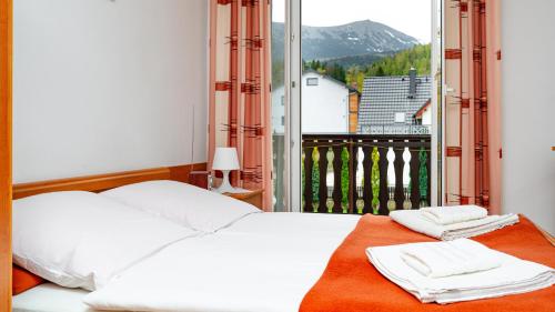 une chambre avec un lit et une grande fenêtre dans l'établissement Willa ASTRA, à Karpacz