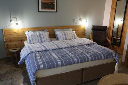 a bedroom with a bed with a blue and white comforter at Lynton Lodge Studios in Keswick