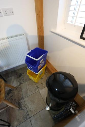 a bathroom with a toilet and a bucket on the floor at Lynton Lodge Studios in Keswick