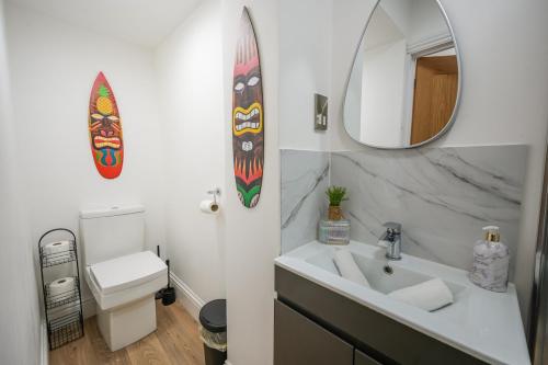 a bathroom with a sink and a mirror and a surfboard at Love Nest in Eastbourne in Eastbourne