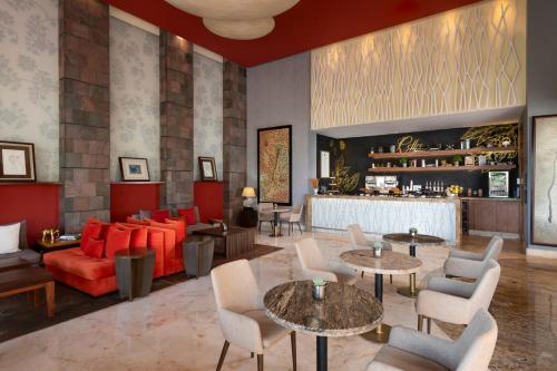 a lobby with a red couch and tables and chairs at Grand Velas Riviera Maya - All Inclusive in Playa del Carmen
