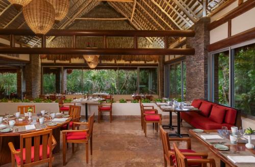 a dining room with tables and chairs and windows at Grand Velas Riviera Maya - All Inclusive in Playa del Carmen
