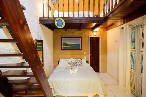 a bedroom with a bed with a wooden staircase at Olho D'Água Pousada in Guaramiranga
