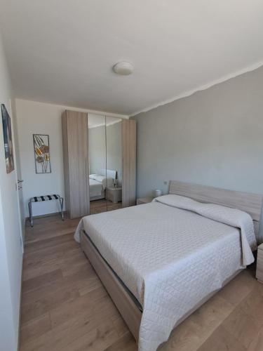 a bedroom with a large white bed and wooden floors at Interno 10 in Capolona