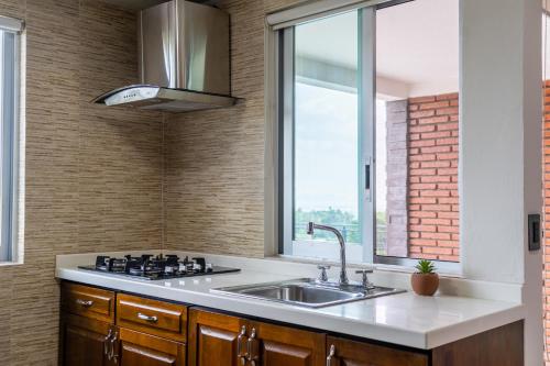 a kitchen with a sink and a window at Galerias Oaxaca Suites in Oaxaca City