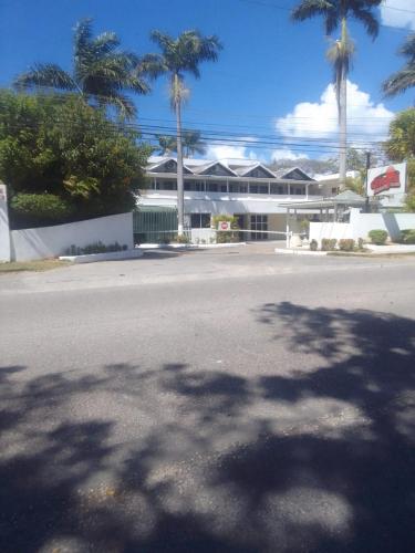 an empty street in front of a building with palm trees at Studio Apt on 7 Mile Beach at Negril Beach Club in Negril