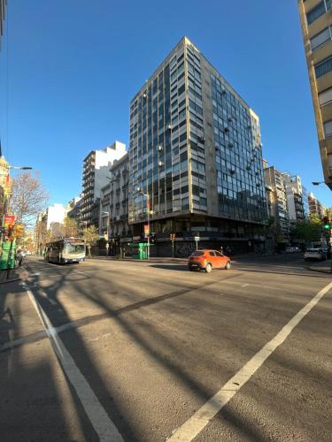 an orange car driving down a city street with buildings at Luminoso y confortable apartamento en el corazón de la ciudad in Montevideo