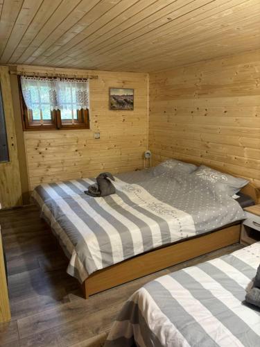 a bedroom with a bed in a wooden cabin at Chata Sovička in Kokava na Rimavica