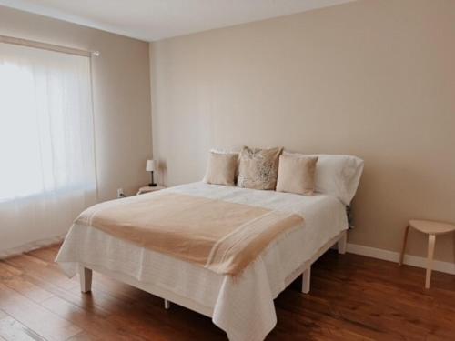 a white bedroom with a large bed with pillows at Centrically Located Hillsboro Home in Hillsboro
