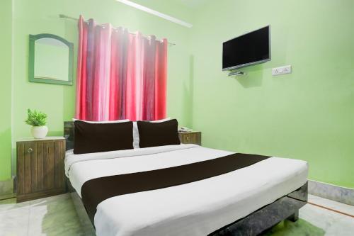 a bedroom with a large bed and a tv at Collection O Chhapra Railway Junction Formerly Hotel City Palace in Chupra