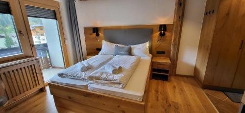 ラムサウ・アム・ダッハシュタインにあるBergidyll 8 by Alpenidyll Apartmentsの白いシーツと枕が備わったベッドのある寝室