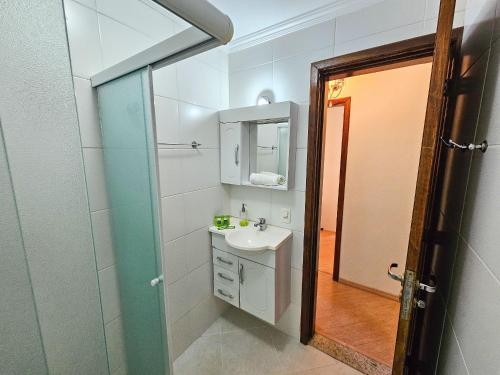 a bathroom with a sink and a mirror at Capivari Flat in Campos do Jordão