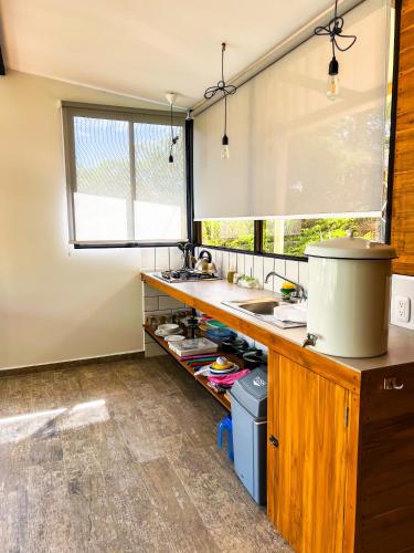 a kitchen with a counter and a sink and a window at Oleadas Maderas in San Juan del Sur