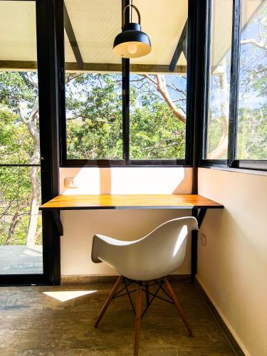 a desk with a chair in front of a window at Oleadas Maderas in San Juan del Sur