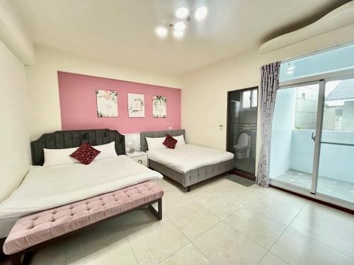 1 dormitorio con 2 camas y pared de color rosa en 小路彎彎民宿 鄰近火車站 前庭有停車位, en Taitung