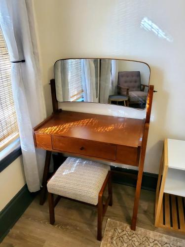 a dressing table with a mirror and a chair at High end 1B apt laundry 10ft ceilings king bed in Wilmington