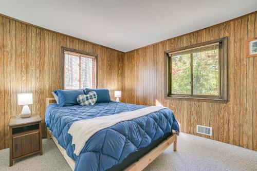 a bedroom with a bed and wood paneled walls at Private Dock, Near Skiing Lakefront Gaylord Home in Arbutus Beach