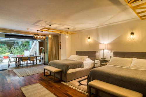 a bedroom with two beds and a dining room at Livin Condesa in Mexico City