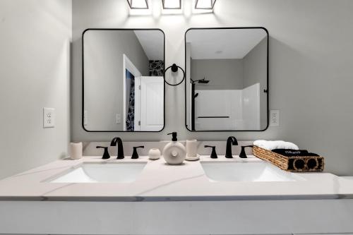 a bathroom with two sinks and two mirrors at Brand New Cozy FirePit Home Near Fort Moore in Columbus