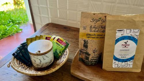 a table with a cup of coffee and a bag of food at Outdoor Cinema Group Friendly Retreat in Pingwe