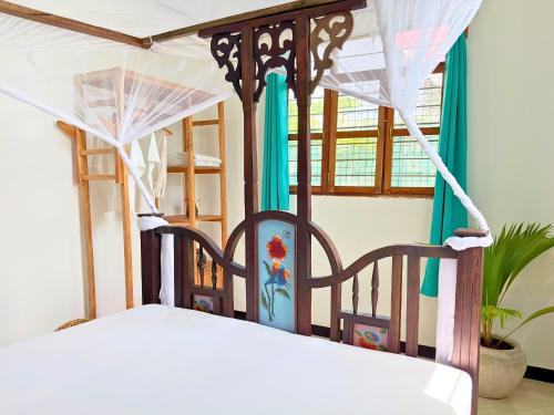a bedroom with a bed with a canopy and a window at Outdoor Cinema Group Friendly Retreat in Pingwe