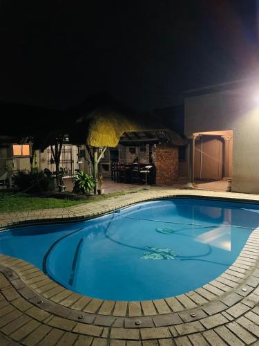 a large blue swimming pool at night at LINGAS inn in Richards Bay