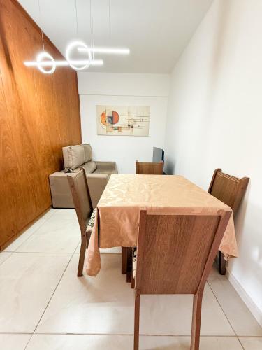 a dining room with a table and chairs and a couch at Apto Centro cambui em Campinas in Campinas