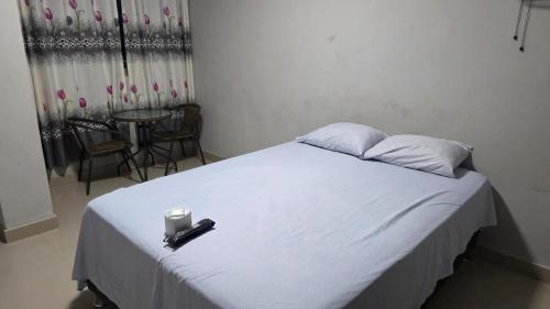 a bedroom with a white bed with a candle on it at Jorge Chavez Hostel in Lima