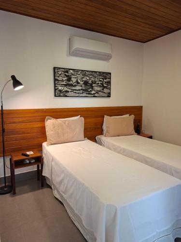 a room with two beds and a lamp at Pousada Casa Viva a Vida in Lençóis