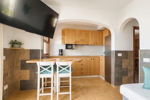 een keuken met een aanrecht en 2 krukken bij Bungalow Golf Splash Park in Maspalomas
