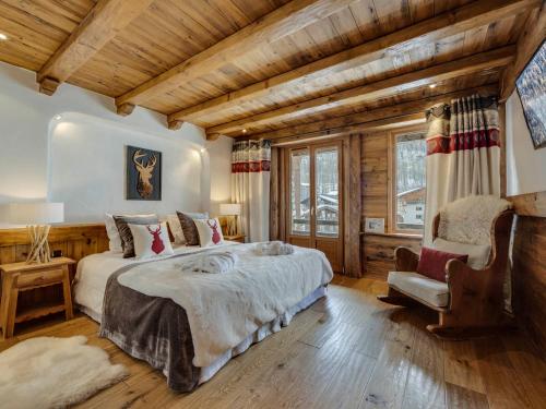 Un dormitorio con una cama grande y un techo de madera. en Chalet prestige 4 chambres, hammam, cheminée, conciergerie - FR-1-694-365, en Val dʼIsère