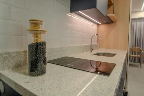 a bottle of seasoning sitting on a counter in a kitchen at Luggo Mauá - Rio de Janeiro in Rio de Janeiro