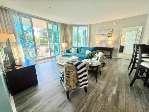 Una sala de estar con un sofá azul y una mesa. en A Wave From it All, en Destin