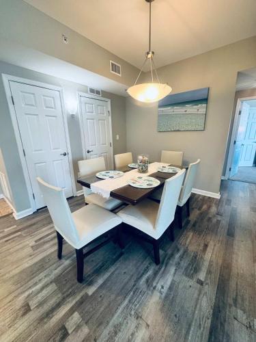 a dining room with a table and white chairs at A Wave From it All in Destin
